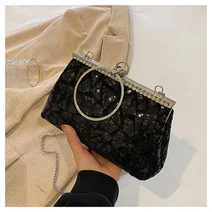 Close-up of black sequined evening clutch with diamond-encrusted silver metal frame and ring