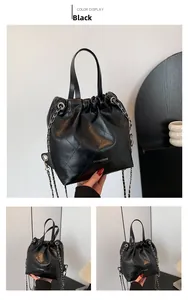 Detail of black quilted leather bucket bag with chain strap and drawstring closure