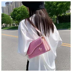 Detailed view of pink rhinestone crossbody bag featuring a cute plaid bear charm and gold chain