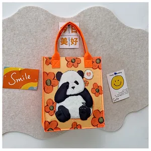 Detail of felt tote bag with orange panda graphic and sturdy webbing handles
