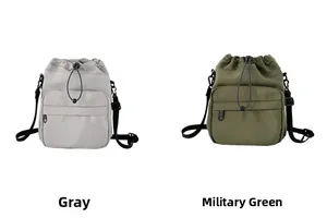 Detail of gray and army green nylon bucket bags featuring drawstring closure and front pocket