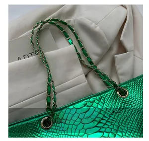 Detail of bright green snake pattern embossed tote bag with gold woven chain handle