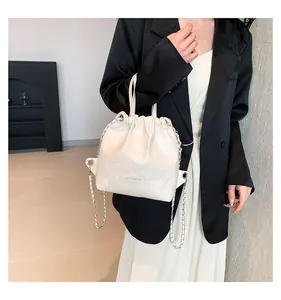 Close-up of cream quilted leather bucket bag with silver chain and drawstring detail