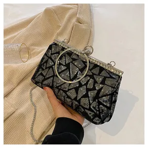 Detail of evening clutch featuring black sequins with silver geometric patterns and metal handle