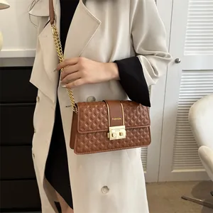 Sac bandoulière marron matelassé avec chaîne dorée et fermoir métallique en vue latérale stylée