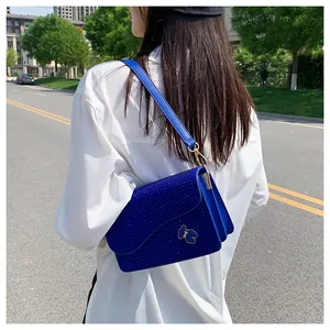 Detail of royal blue rhinestone saddle bag with a crystal bow and golden clasps