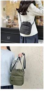 Detail view of nylon drawstring bucket bag showing front zip pocket and adjustable strap