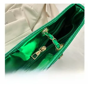 Detail of smooth gold zipper closure on lime green metallic faux leather tote bag