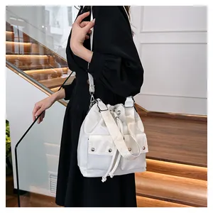 Macro detail of white nylon bucket bag with silver studs and drawstring closure
