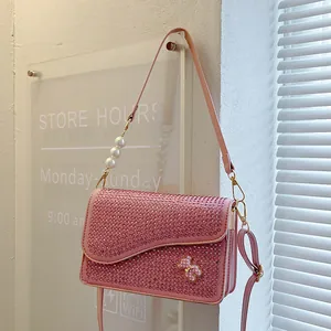 Pink rhinestone crossbody bag with bow detail and large decorative pearl strap