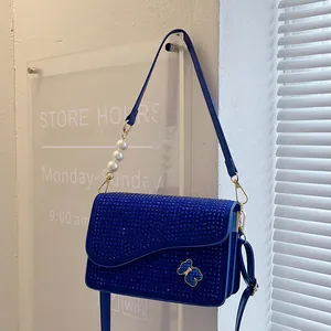 Sparkling blue crossbody bag with rhinestones, pearls, and gold-tone bear detail