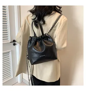 Detail showing the black quilted leather texture and chain strap of this casual handbag