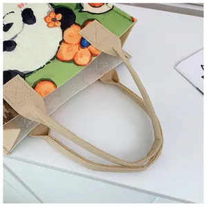 Detail of cross-stitch reinforced handle and panda floral print on felt tote bag