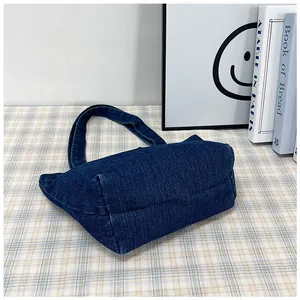 Close-up of large capacity denim tote bag with washed texture on a checkered tablecloth