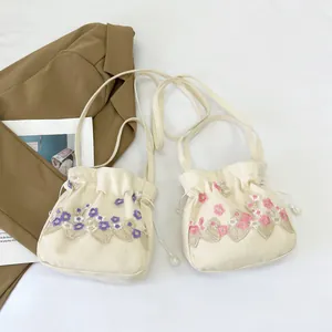 Handmade floral embroidered canvas bucket bag with drawstring and pearl tassels