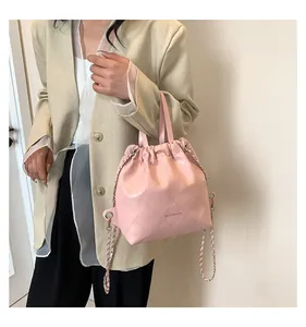 Detail of pink quilted drawstring bucket bag with OH FASHION print and chain strap