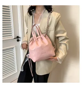 Detail of pink quilted bucket bag with chain strap and OH FASHION print on leather surface