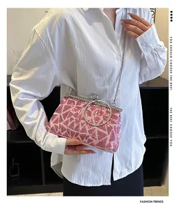 Detail view of pink sequin clutch with silver circular handle and metallic chain strap