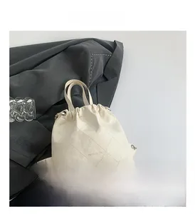 Close-up of cream white bucket bag featuring diamond quilting and OH FASHION print