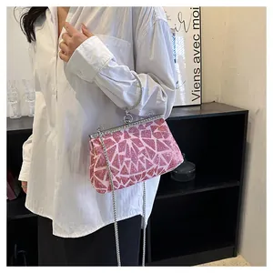 Detail of pink sequin clutch with silver metal ring handle and chain strap for evening events
