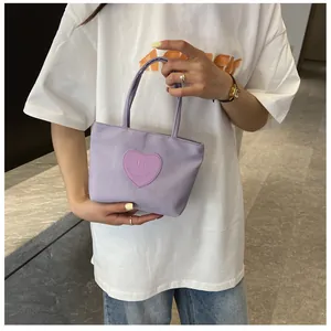 Detail of lavender nylon mini tote bag with heart-shaped stitched patch and smiling face