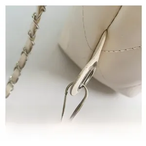Detailed view of cream quilted faux leather with silver-tone chain strap and hardware