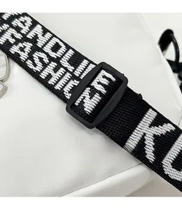 Détail de la bandoulière tissée noire réglable avec broderie de lettres de mode blanches