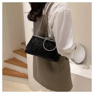 Detail of elegant black sequin evening bag with silver metal ring handle and chain strap