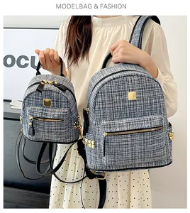 Detail of blue and white tweed backpacks in medium and small sizes with leather straps