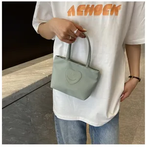 Detailed close-up of a mint green nylon mini tote bag with heart smile patch