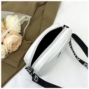 Détail du sac bandoulière en nylon blanc avec large sangle réglable et fermeture éclair argent