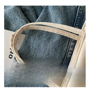 Detailed close-up of reinforced double-stitching on durable white nylon handbag handles