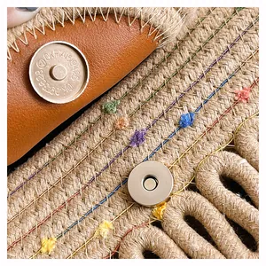 Détail du sac cabas en paille tissée avec rabat en cuir marron et fermoir aimanté en métal