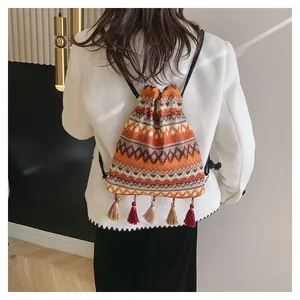 Dettaglio dello zaino bohémien con coulisse, motivi geometrici intrecciati e nappe