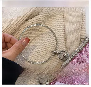 Detailed macro of pink sequins with silver rhinestone encrusted ring handle on a clutch bag