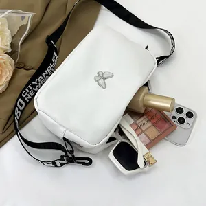 Petit sac carré blanc en cuir avec boucle papillon et large bandoulière nylon