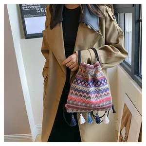 Dettaglio borsa etnica a secchiello con motivi geometrici e nappe colorate