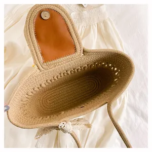 Détail d'un sac cabas tissé avec rabat en cuir marron et nœud en dentelle décoratif