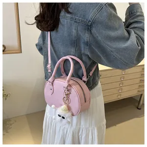 Dettaglio della mini borsa rosa con ciondolo di peluche e manici cilindrici