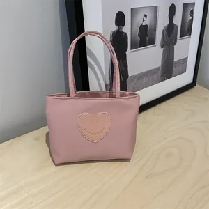Pink mini nylon handbag for women with heart smile patch and double handles for daily use