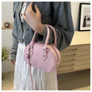 Dettaglio della mini borsa a tracolla rosa con manici tondi in stile lifestyle