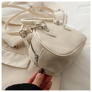 Dettaglio della mini borsa a tracolla crema con hardware argento e inserti in stile moto
