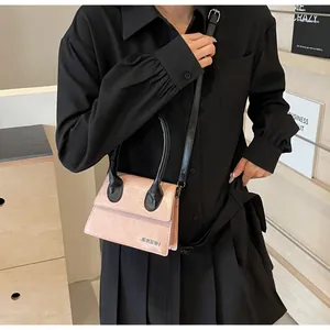 Detalle del mini bolso bandolera rosa con asa negra y logotipo metálico JINGPIN