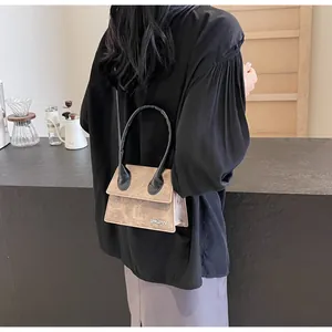 Detalle de mini bolso beige con textura mate y placa metálica con el logo de JINGPIN