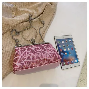 Detailed shot of pink sequin evening bag featuring metal ring handle and rhinestone trim