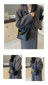 Close-up of black leather bucket bag with natural texture and thin shoulder strap