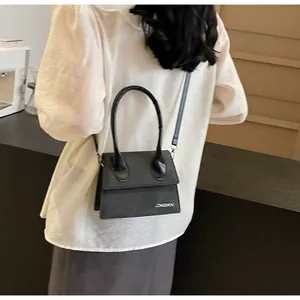 Detalle de un mini bolso bandolera negro con logo JINGPIN y correa larga desmontable