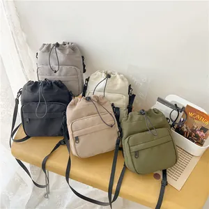 Large nylon drawstring bucket bag shown in five casual colors with adjustable straps