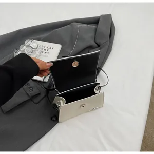 Detalle del mini bolso bandolera blanco crema con forro negro y cierre magnético plateado