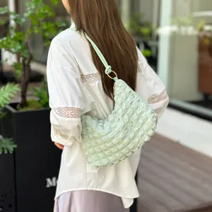 Détail du sac à bandoulière vert clair plissé effet bulle avec anneaux en métal doré